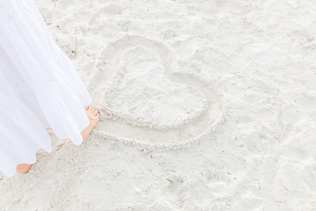 Drawing  heart on the sand beachの写真素材