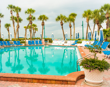 Swimming pool with chaise lounge and umbrellas at tropical resortのeditorial素材