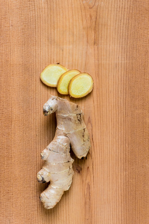 Sliced fresh ginger root on wooden tableの写真素材