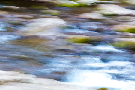 Blurred water in mountain river. Natural abstract background, defocused with  panning motion.の写真素材