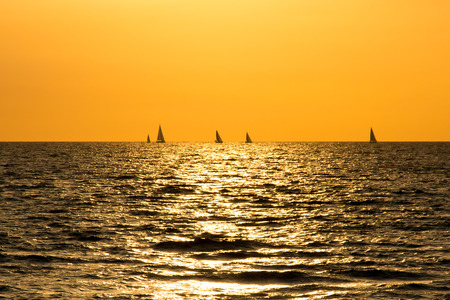 Sunset on Atlantic ocean with the yachts on the horizon.の写真素材