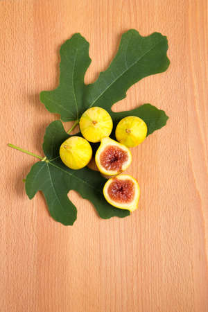 Yellow tiger figs with leaves on wooden background.の写真素材