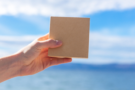 an image of a hand holding a cardboard boxの写真素材