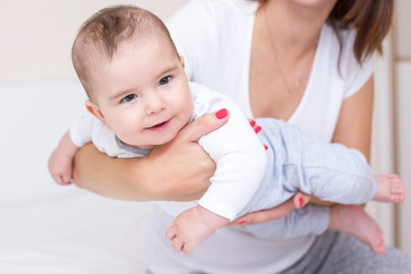 young mother is playing with her happy baby