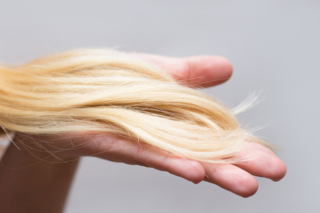 an image of a Woman holding problematic hair in her handの写真素材