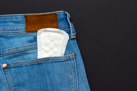 pms concept. an image of a menstrual pad in a jeans pocketの写真素材