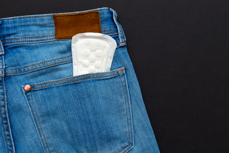 pms concept. an image of a menstrual pad in a jeans pocketの写真素材