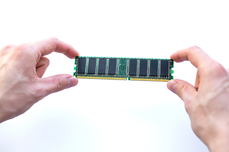 male hands holding ram memory card on a white backgroundの写真素材