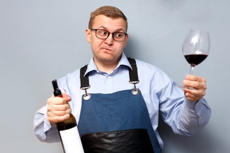 male sommelier is checking and testing red wine and making notesの写真素材