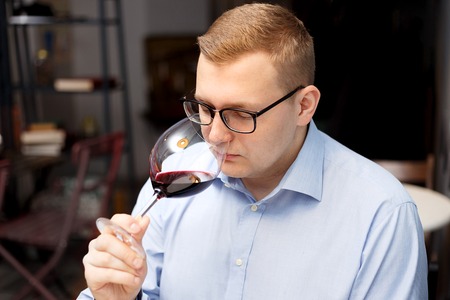 a man addicted to alcohol is drinking wine from a glassの写真素材