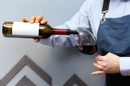 male sommelier is checking and testing red wine and making notesの写真素材