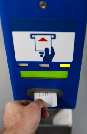 Person inserting a ticket at a Vienna subway station machine, illustrating city travel routine and efficient ticket management.
