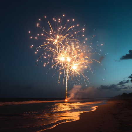 Luminous golden fireworks exploding against dusky coastal horizon, sparkling reflections dancing across rippling shoreline waves under deepeningの素材