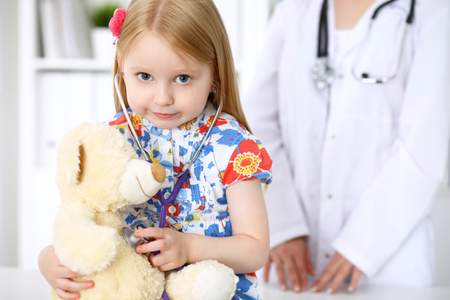 Little girl examining her Teddy bear by stethoscope. Health care, child-patient trust conceptの写真素材