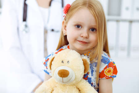 Happy smiling girl at usual medical inspection. Doctor and patient in clinic. Medicine, healthcare conceptsの写真素材