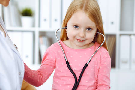 Happy smiling child patient at usual medical inspection. Doctor and little girl in clinic. Medicine, healthcare conceptsの写真素材