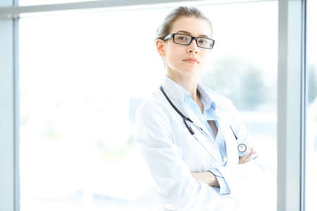 Beautiful woman doctor with stethoscope smiling charmingly and ready to help patients in the modern hospital. Medicine conceptの写真素材