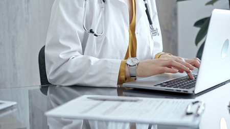 Doctor working on laptop with stethoscope on the glass desk. Medicine and Health care