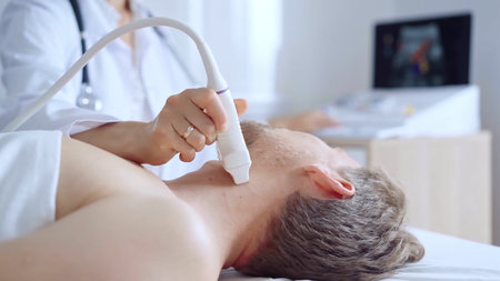 Doctor woman performing neck ultrasound exam on male patient. Medicine service concept. Thyroid...