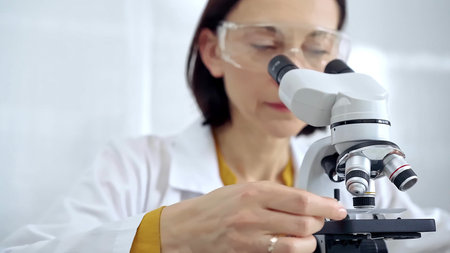 Woman scientist using microscope in laboratory. Microbiology science concept