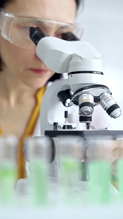 Woman scientist using microscope in laboratory. Microbiology science concept