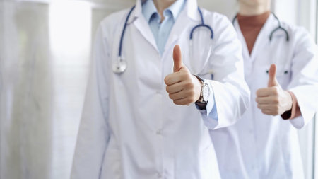 Two doctors showing thumbs up in hospital corridorの写真素材