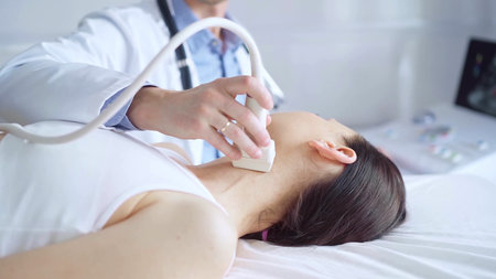 Doctor man is using ultrasound equipment on neck of female patient lying down for a medical...