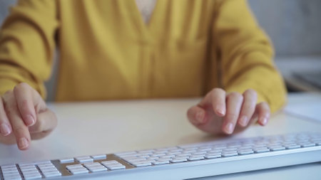 Businesswoman with yellow blues is working on a computer keyboard in the office. Business conceptの写真素材