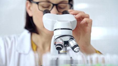Woman scientist using microscope in laboratory. Microbiology science concept