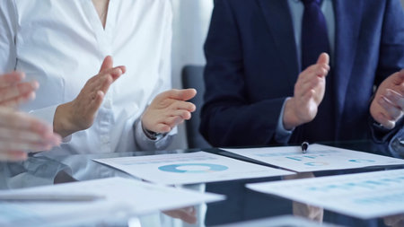 Business team wearing suits clapping hands after successful presentation. Businesspeople diverse...
