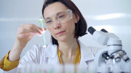 Scientist researcher with protective glasses examining lab tube
