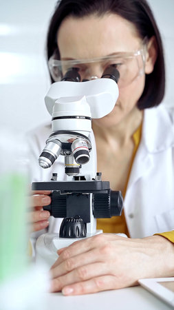 Woman scientist using microscope in laboratory. Microbiology science concept