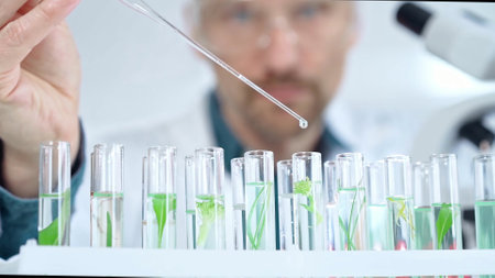 Man researcher with safety glasses is working with lab tubes using a pipette in laboratory, close-up of lab equipment. Science and medicineの写真素材