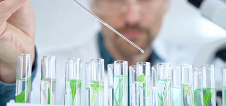 Man researcher with safety glasses is working with lab tubes using a pipette in laboratory, close-up of lab equipment. Science and medicineの写真素材