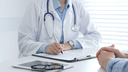 Female medical professional filling prescription, advising patient on health issues during clinical...