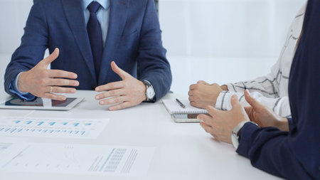 Business team collaborating in an office, analyzing financial data through digital tablets and...