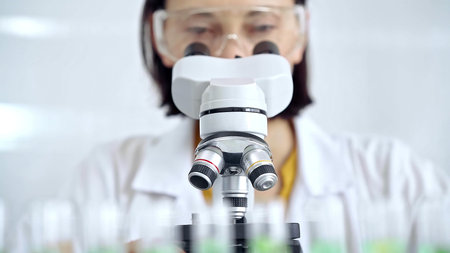 Woman scientist using microscope in laboratory. Microbiology science concept