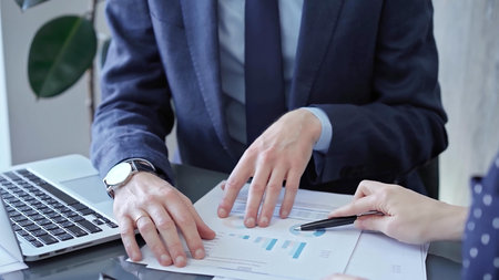 Two professionals analyzing a pie chart during a strategic business meeting. Business meeting with...
