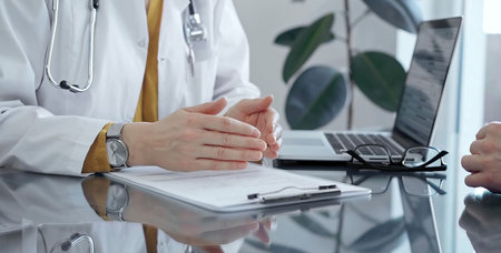Doctor and patient consultation with clipboard and medication notes. Close-up view of unknown female...