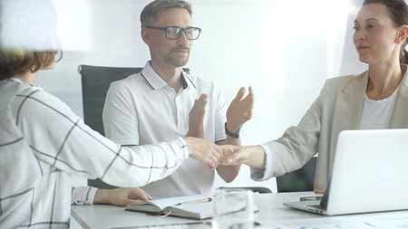 Businesswomen partners are shaking hands after successful negotiation, colleagues clapping,...