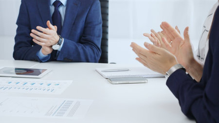 Professional business team clapping hands, celebrating successful presentation, showcasing...