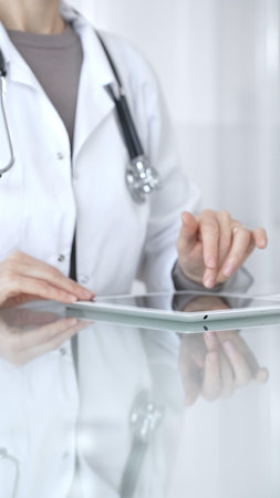 Doctor person using digital tablet, providing modern medical consultation and health insurance support information. Medicine and health careの写真素材