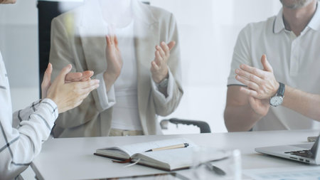 Business team applauding after achieving a goal during a productive meeting in a modern office...