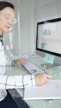 Woman analyst working on computer, analyzing business data with charts and graphs, marketing report on screen. Businesspeople conceptの写真素材