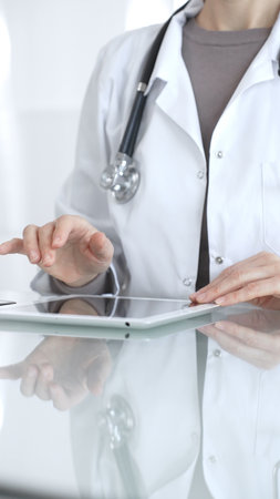 Doctor person using digital tablet, providing modern medical consultation and health insurance support information. Medicine and health careの写真素材