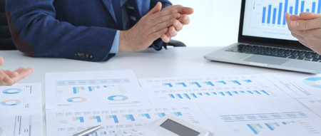 Analyzing financial data using charts, graphs, and reports during an office meeting, collaborating...