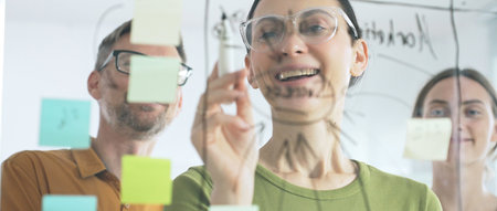 Business people team brainstorming strategic goals, mapping innovative concepts on transparent...