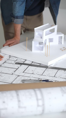 Architects collaborating on building design, a female showing a colleague a blueprint layout while...