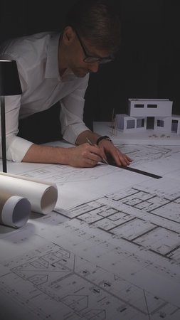 Architect working on blueprint with compass, developing engineering plans and creative building...