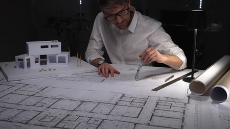 Architect designing modern building plan, creating architectural model with precision and...